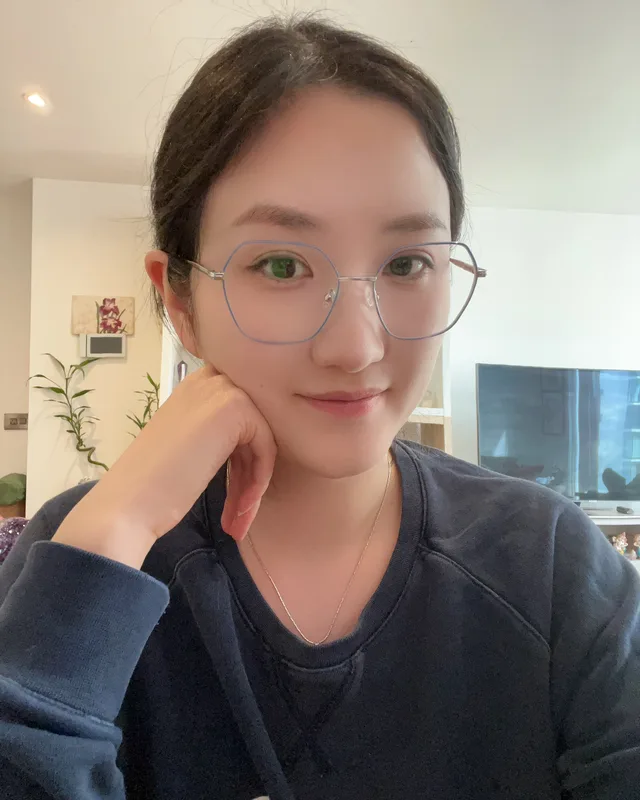 Yanting Zuo, resting her chin on her hand, smiling softly in natural light